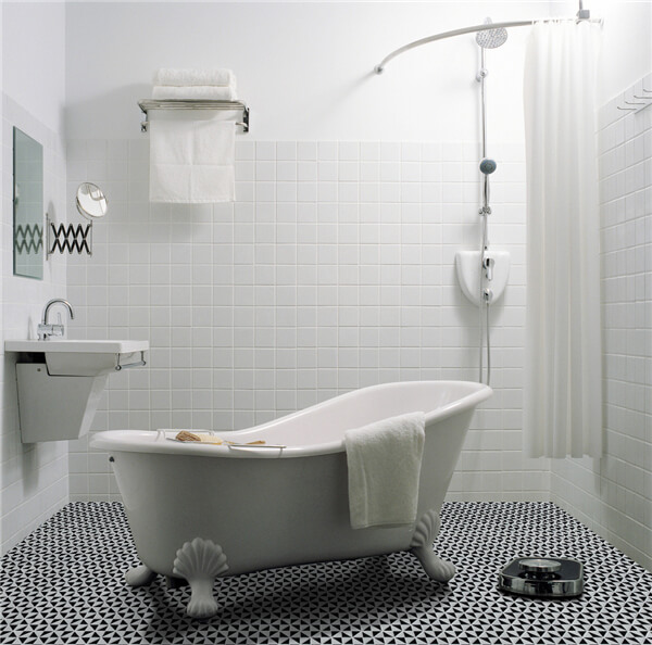 A classic bathroom with free-standing bathtub, 1” windmill pattern tile flooring, and white tiling wall decor.