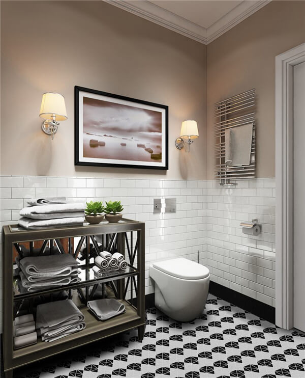 A neat bathroom done with hanging art picture, towel storage, tankless toilet and 2” triangle black and white diamond tile flooring