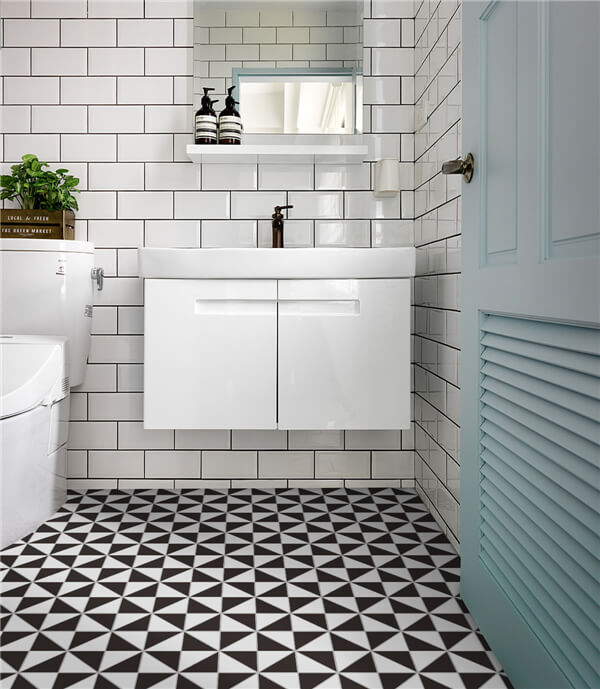 A small bathroom stands out with 4” windmill black white triangle ceramic tile flooring
